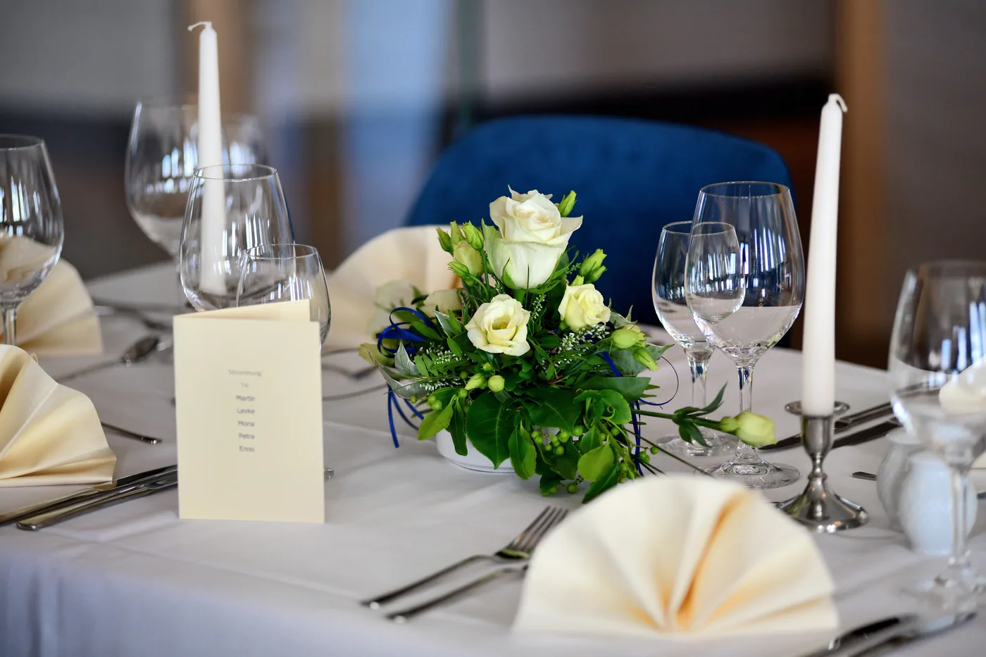 Festlich eingedeckte Tafel mit weißen Rosen und Kerzen im tween